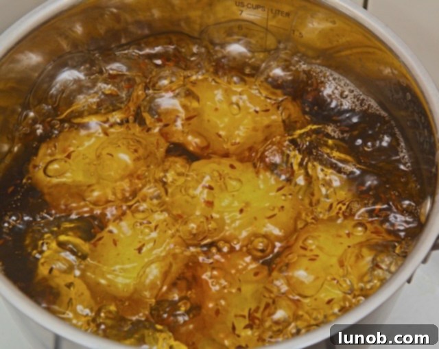 Fork testing the tenderness of boiling potatoes.