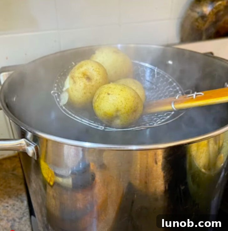 Removing boiled potatoes from water with a spider strainer.