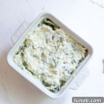 Creamy No-Mayo Spinach Artichoke Dip 6 Cheese mixture in an oven safe dish.