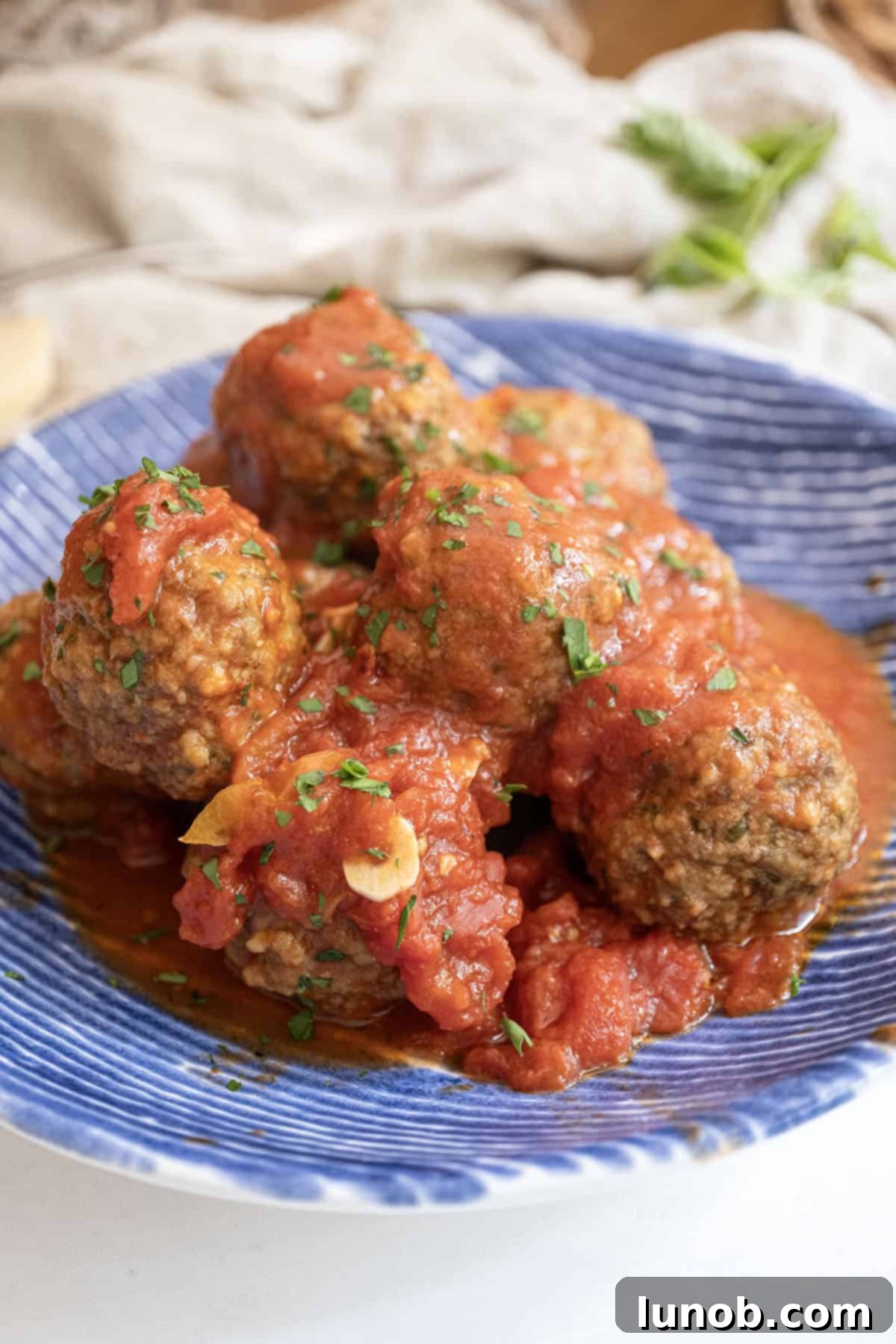 Meatballs covered in tomato sauce in a bowl.