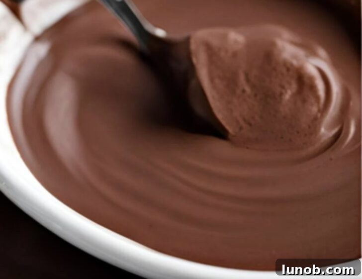 A close-up shot of a spoon in a very thick Italian hot chocolate, emphasizing its pudding-like consistency.