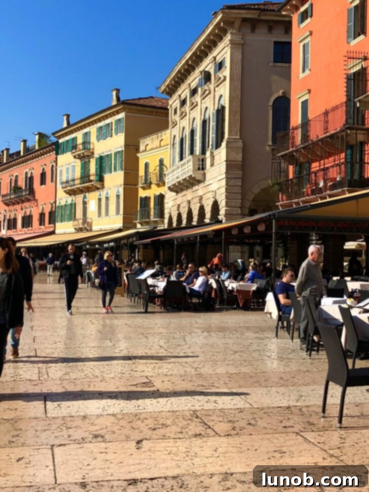 People enjoying al fresco dining in the marble-floored main city center of Verona, Italy