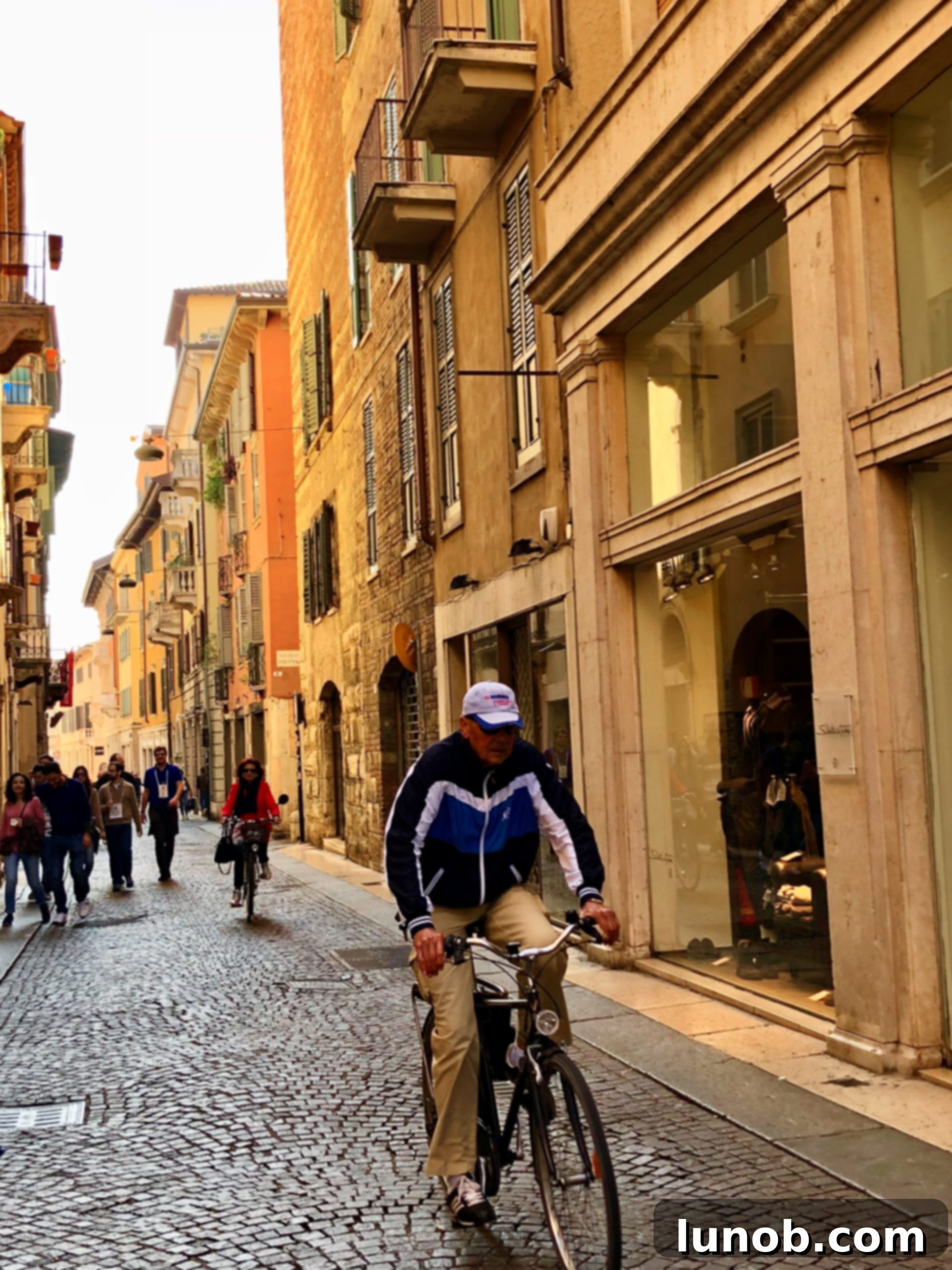 Colorful Verona street with yellow and orange buildings and hanging plants