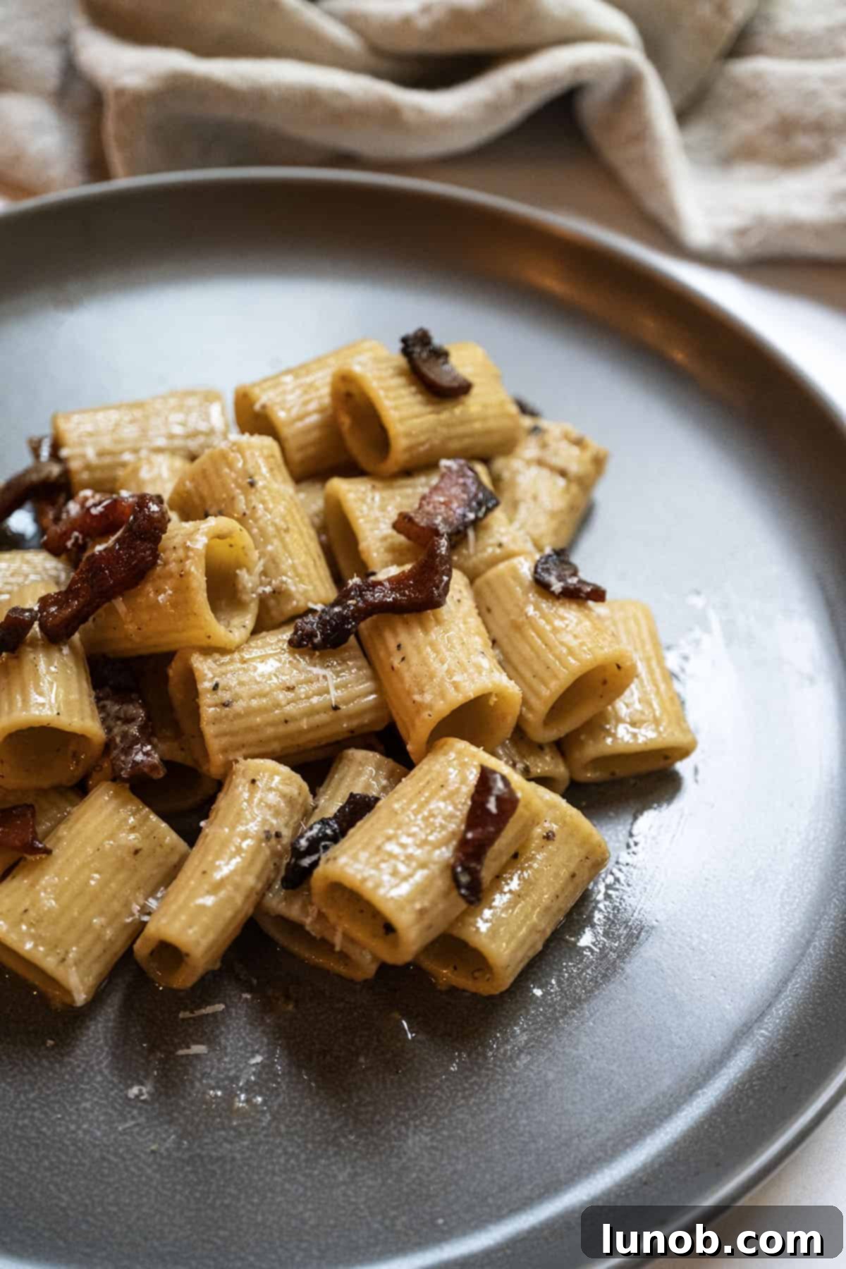 Pasta Alla Gricia: Rome's Simple Perfection 2 A beautifully plated dish of Pasta alla Gricia, adorned with crispy guanciale and grated Pecorino Romano.