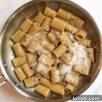 Pasta Alla Gricia: Rome's Simple Perfection 11 Finely grated Pecorino Romano cheese is gradually added to the pasta in the pan while tossing.