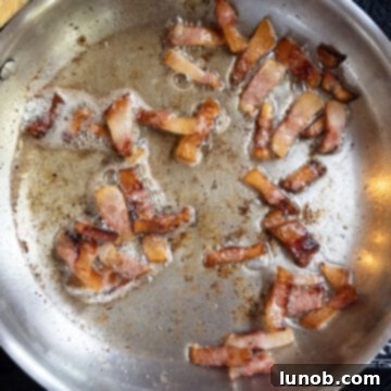 Pasta Alla Gricia: Rome's Simple Perfection 6 Guanciale slowly frying in a pan, rendering its fat to golden crispiness.