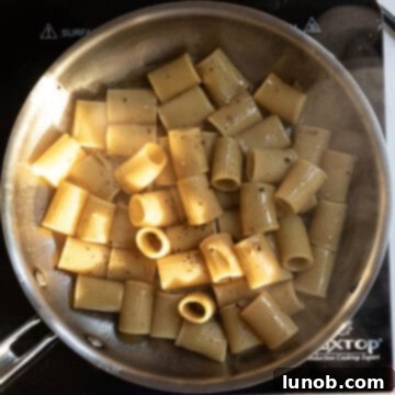 Pasta Alla Gricia: Rome's Simple Perfection 9 The pasta is continuously tossed in the pan to emulsify the sauce, creating a creamy texture.