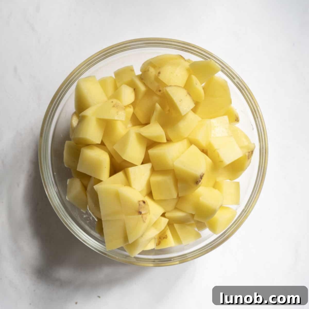 Velvety Potato and Onion Soup 4 Potatoes chopped to ¾ inch pieces in a bowl.