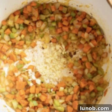 Velvety Potato and Onion Soup 6 Garlic added to the pot with carrots, onion, and celery to saute.