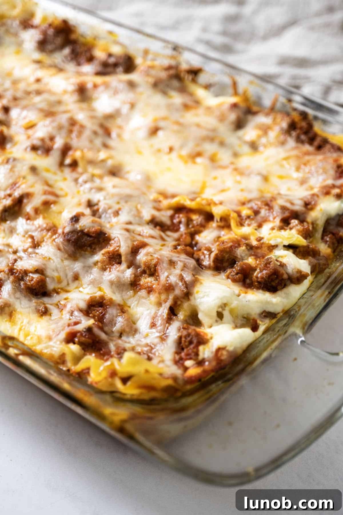 A perfectly baked lasagna still in its baking dish, golden and bubbling, ready to be rested.