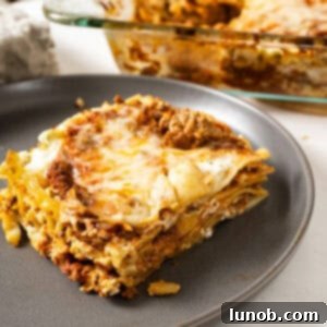 A square of lasagna on a plate.