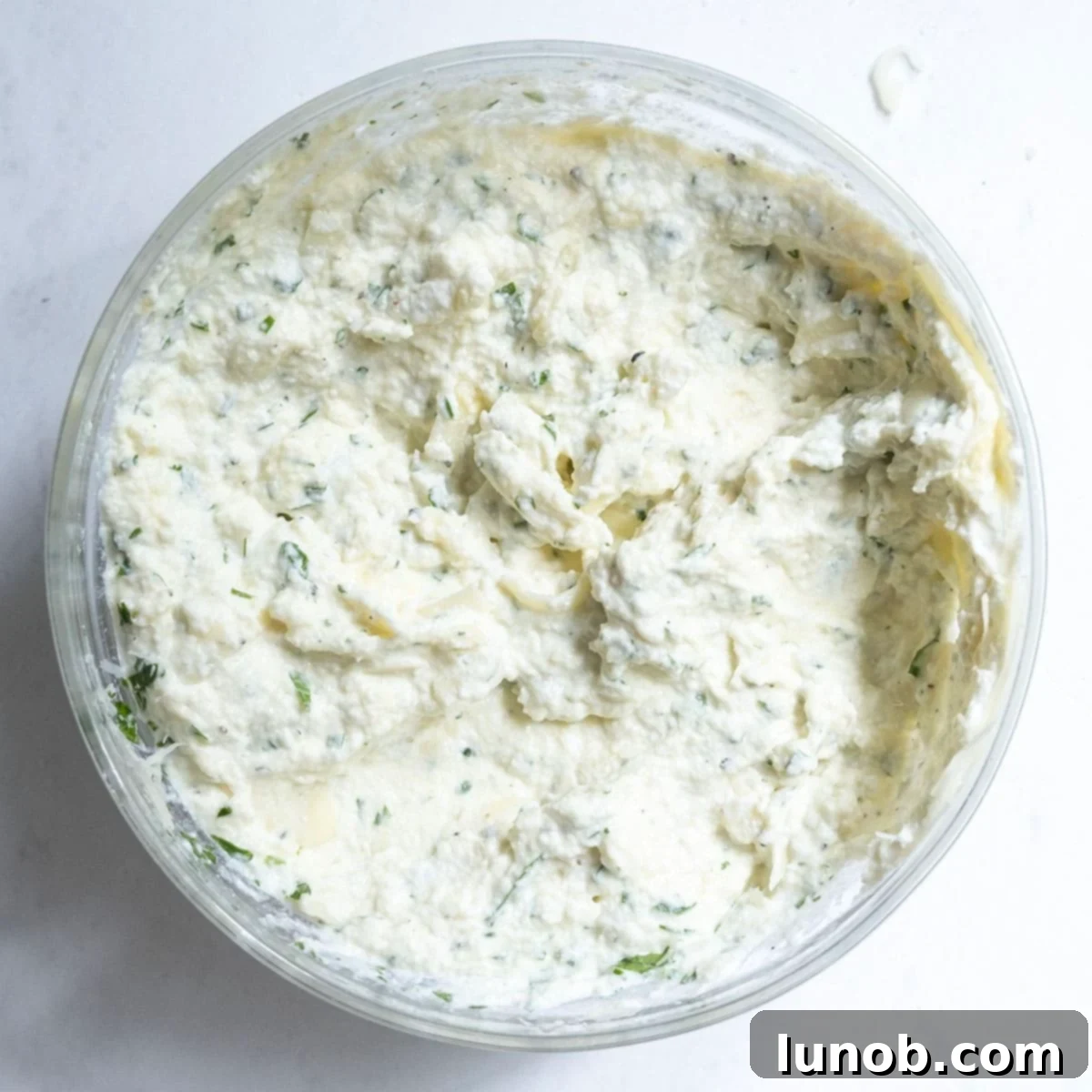 Ricotta cheese combined with eggs, parmesan, mozzarella, and herbs in a bowl, ready for the lasagna layers.