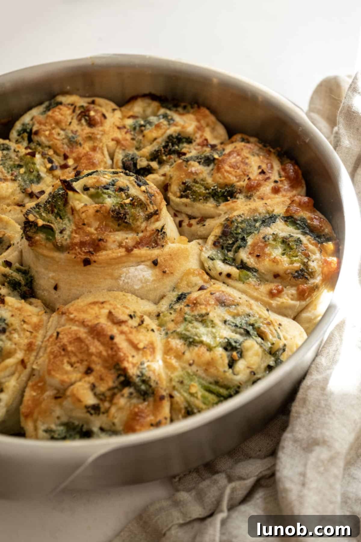 Beautifully baked veggie pinwheels in a cake pan, garnished and ready to serve.