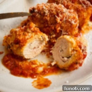 Chicken rollatini cut open with ricotta filling inside.