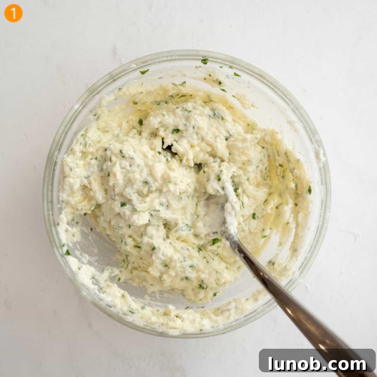 A bowl of creamy, seasoned ricotta filling, ready for stuffing.