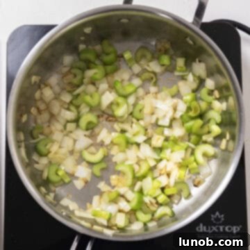 Ultimate Italian Sausage Stuffed Mushrooms 4 Sauteed celery and onion glistening in melted butter in a pan.
