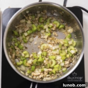 Ultimate Italian Sausage Stuffed Mushrooms 5 Finely chopped mushroom stems added to sauteed celery and onion in a pan.