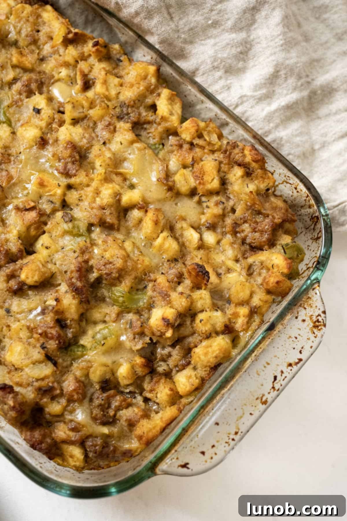 Savory Italian Sausage Thanksgiving Stuffing 2 Italian sausage stuffing baked in a glass baking pan, perfectly golden and inviting for Thanksgiving.