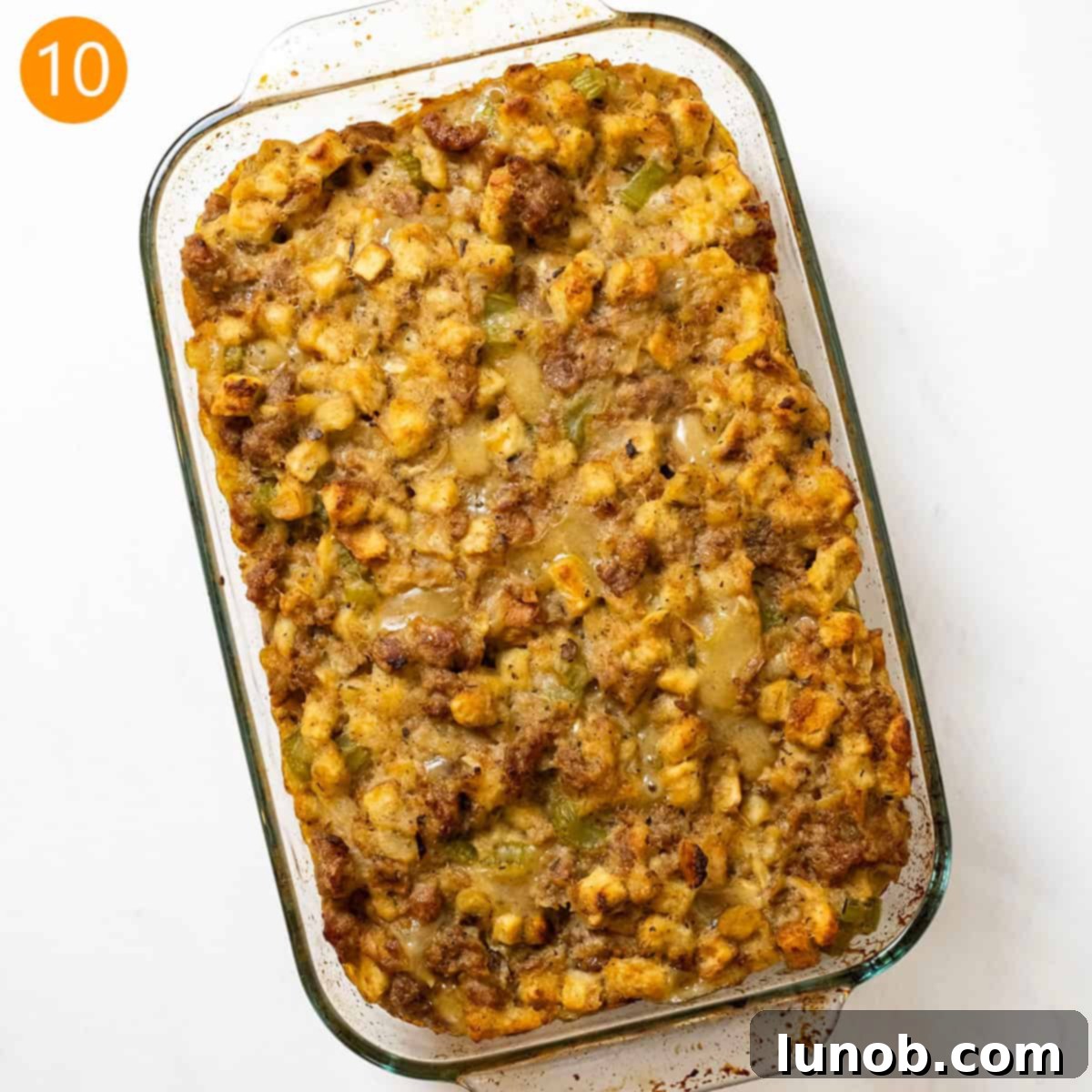 Savory Italian Sausage Thanksgiving Stuffing 11 Golden-brown Italian sausage stuffing baked to perfection in a glass baking pan, ready to be served.