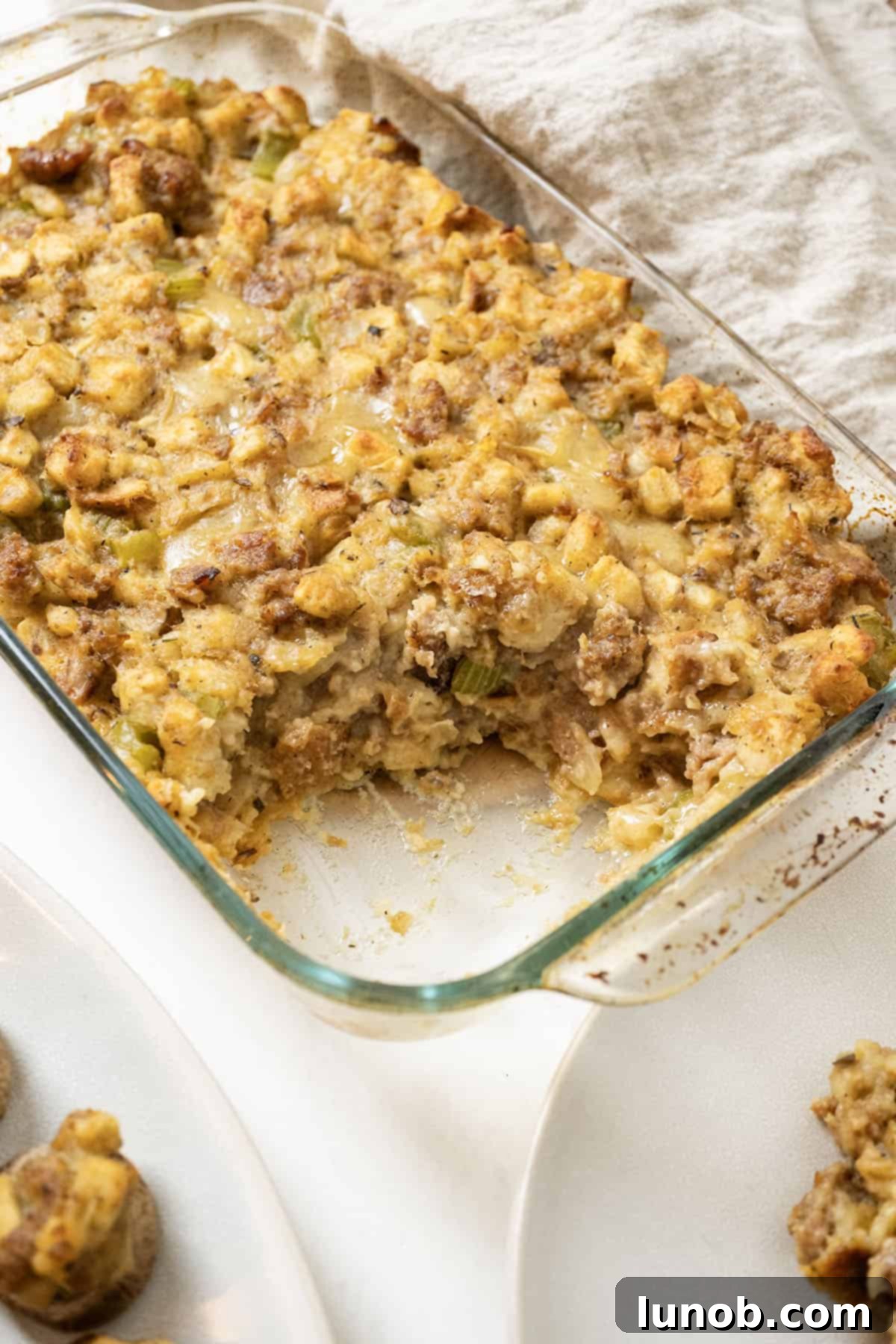 Savory Italian Sausage Thanksgiving Stuffing 12 A large baking dish of golden-brown Italian sausage stuffing, perfectly baked and ready to be served at a holiday feast.