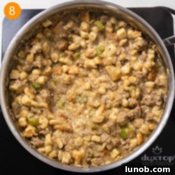 Savory Italian Sausage Thanksgiving Stuffing 9 Fully combined stuffing mixture in a saucepan, showing a moist and flavorful texture with both mashed and intact bread cubes.