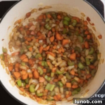 Comforting Chicken Tortellini Soup 7 The sauteed vegetables in the pot, seasoned with spices, releasing their aromas.