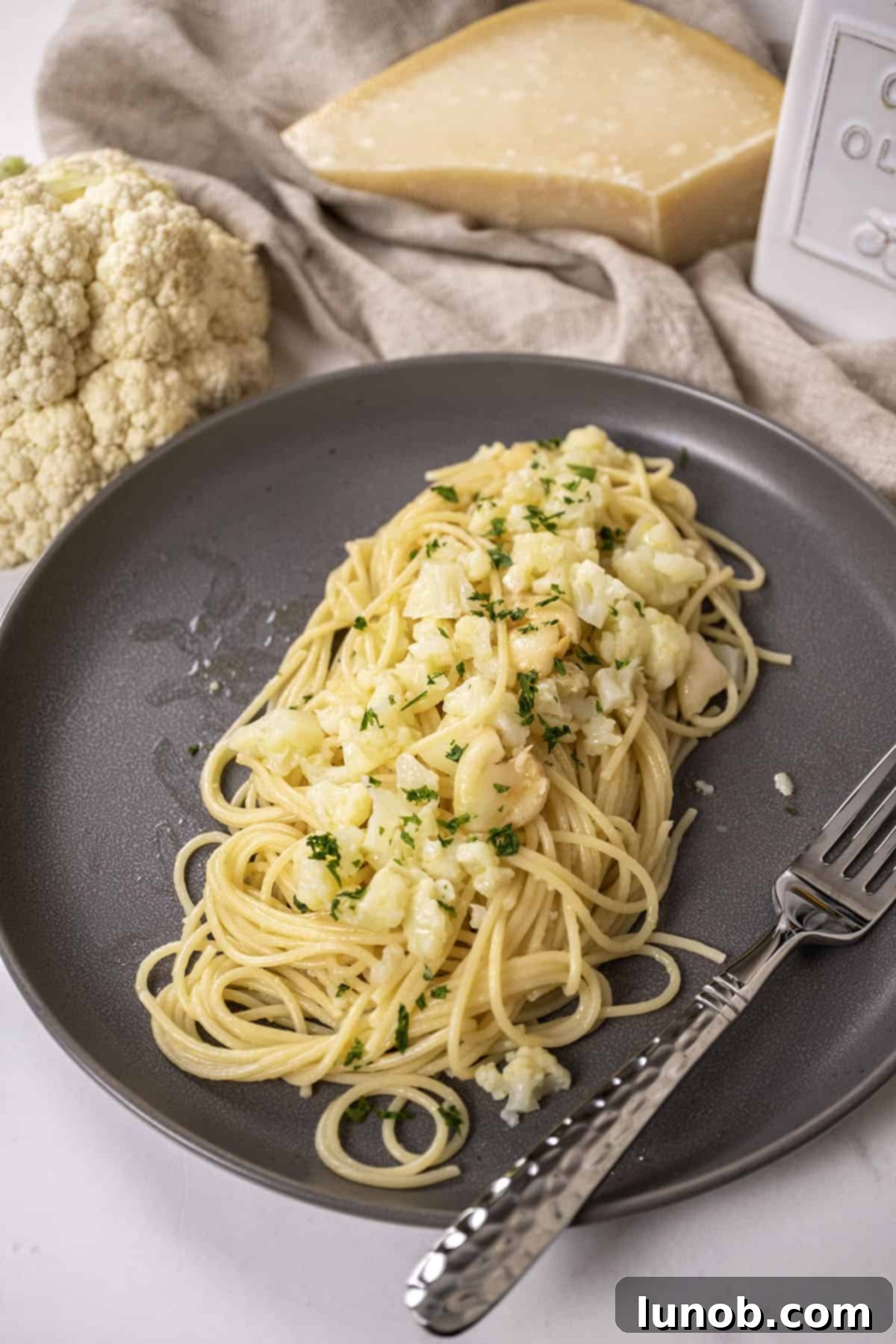 Roasted Cauliflower Pasta 2 spaghetti with cauliflower plated on a dish garnished with parsley.