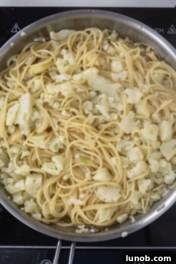 Roasted Cauliflower Pasta 7 spaghetti added to pan with cauliflower and garlic.