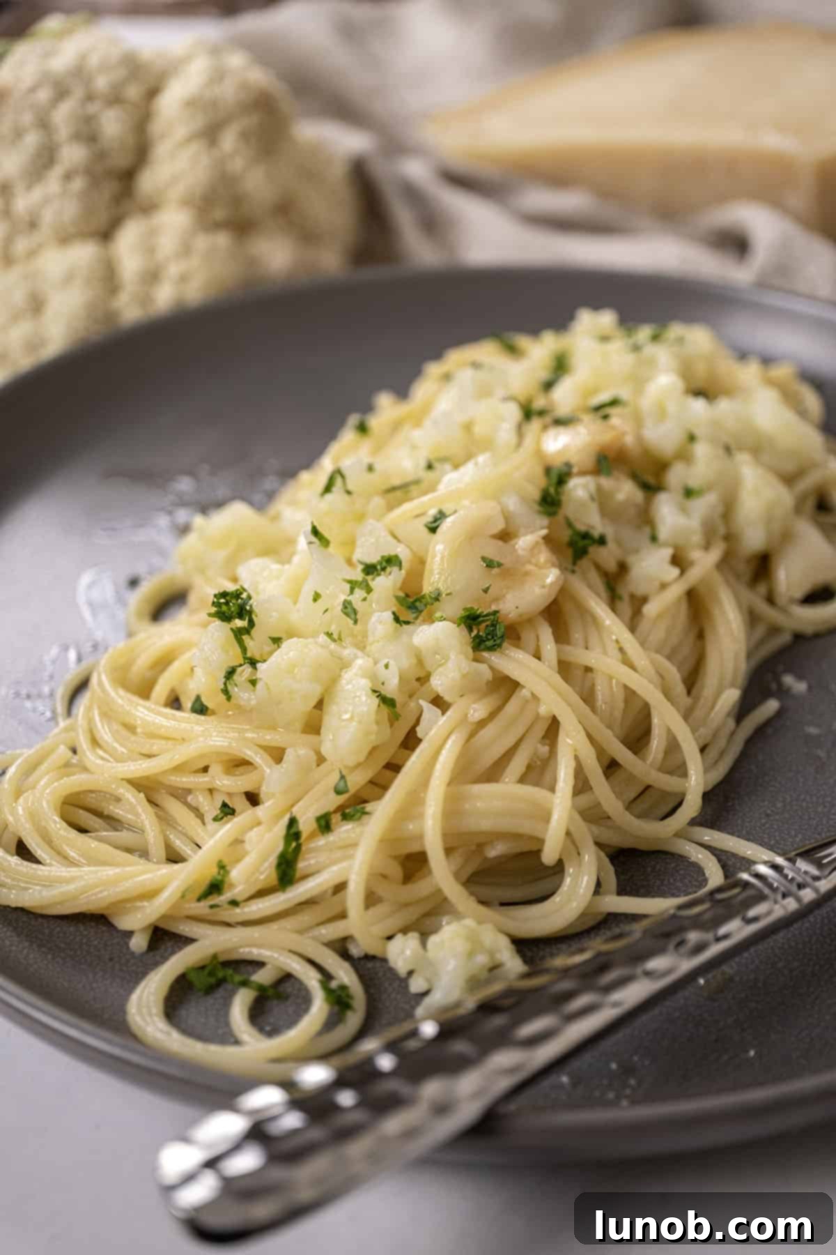 Roasted Cauliflower Pasta 8 spaghetti with cauliflower plated on a dish garnished with parsley.