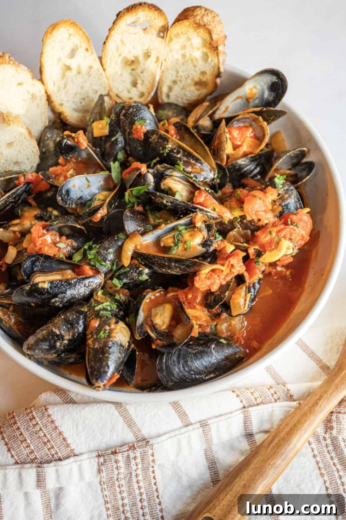 Mussels Fra Diavolo in a serving bowl with crostini.