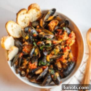 Mussels Fra Diavolo in a serving bowl with crostini.