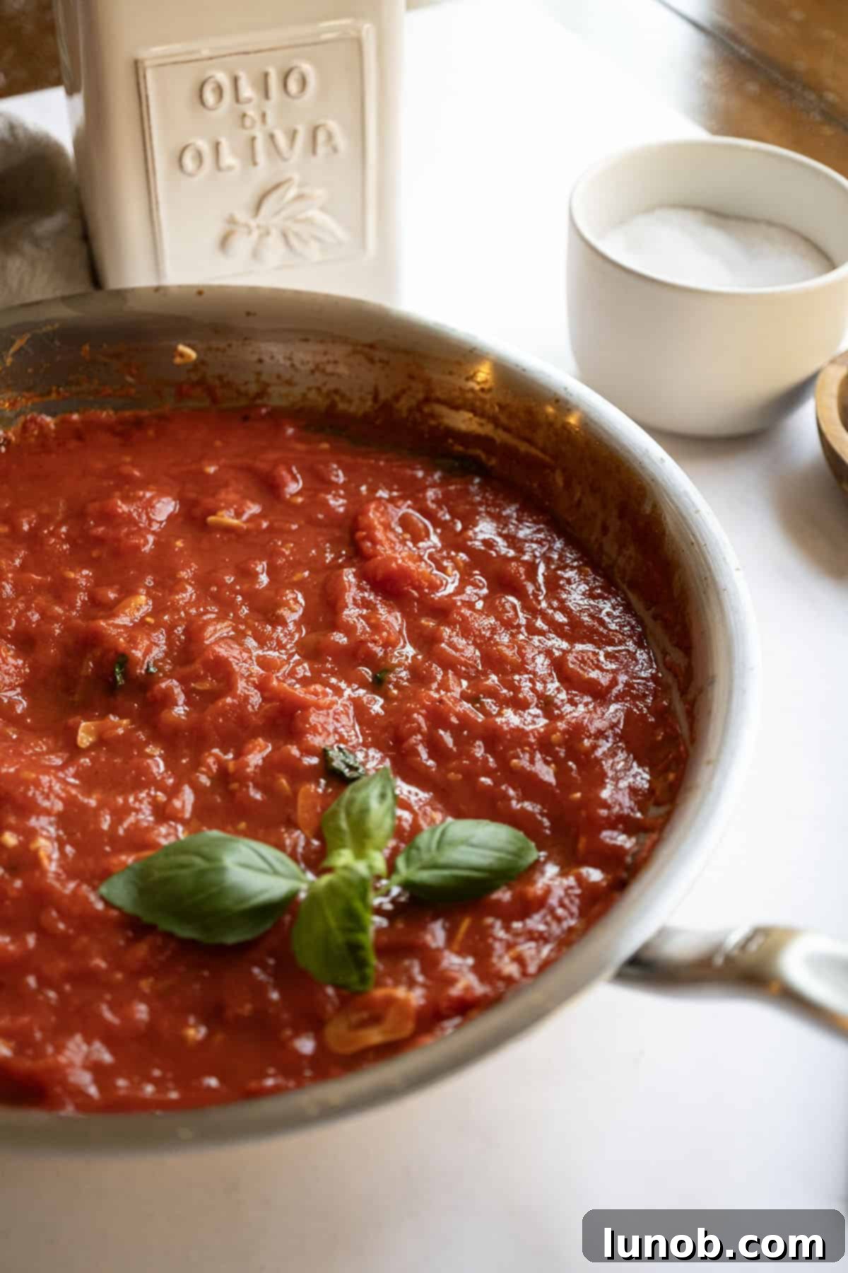 Marinara sauce in a pan garnished with basil. 