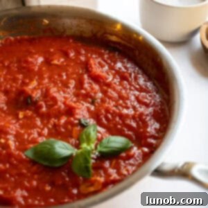 Marinara sauce in a pan garnished with basil.