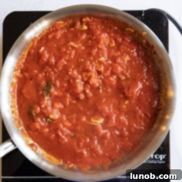 Tomatoes simmering in a sauce pan.