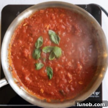Fresh basil added to simmering tomato sauce.