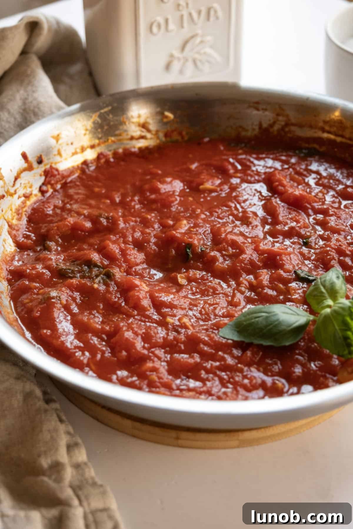 Marinara sauce in a pan garnished with basil.