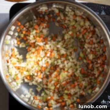 Authentic Italian Lentils 4 Finely chopped carrots, onion, and celery sautéing in a saucepan.