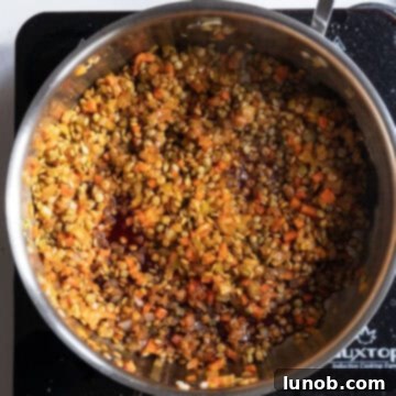 Authentic Italian Lentils 8 Red wine simmering with lentils in a saucepan.
