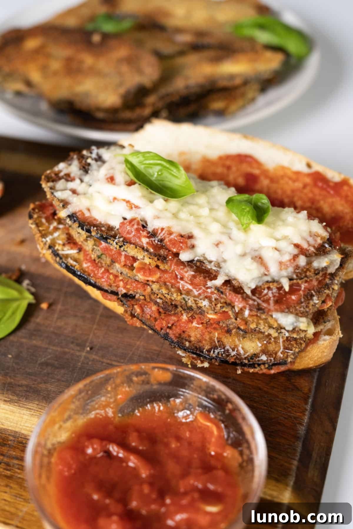 Eggplant topped with marinara, parmesan, and mozzarella on a roll.