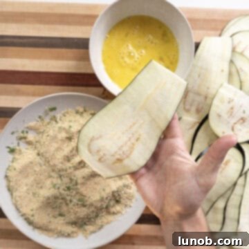 The dredging station with breadcrumbs, egg, and a plate of eggplant.