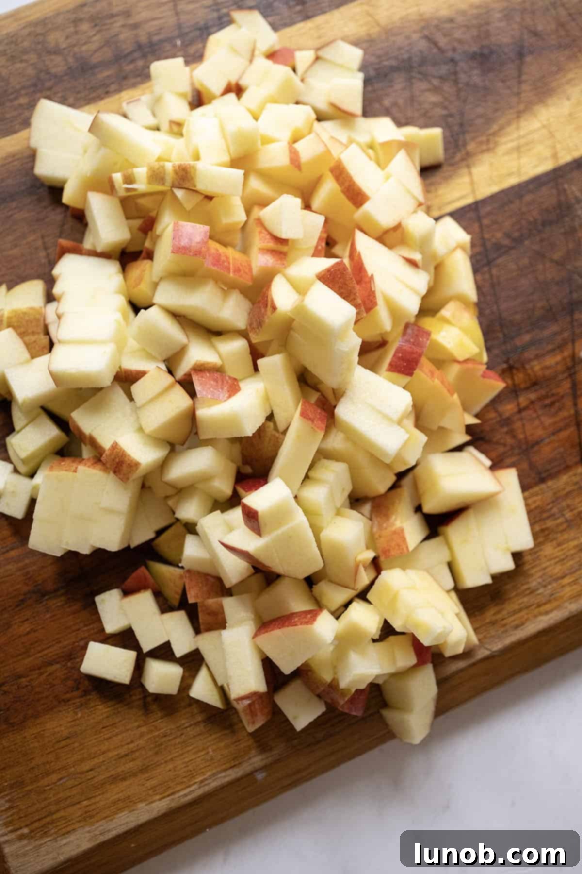 Golden Apple & Spice Chutney 4 Apples expertly chopped on a cutting board, ready for making spiced apple chutney.