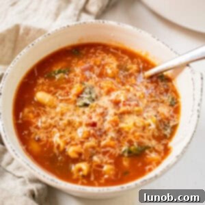 Traditional Italian Pasta Fagioli 12 A close-up shot of a bowl of Pasta Fagioli, topped with a generous sprinkle of Parmesan cheese.