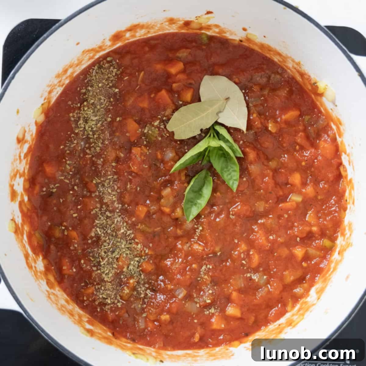 Traditional Italian Pasta Fagioli 7 Crushed tomatoes, fresh basil, remaining seasonings, and bay leaves added to the aromatic sofrito and tomato paste mixture.
