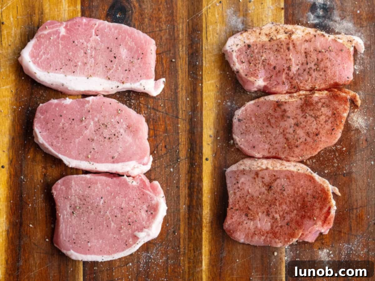 Ultimate Cast Iron Boneless Pork Chops 5 Boneless pork chops seasoned with paprika, garlic powder, and onion powder on a cutting board, ready for cooking.