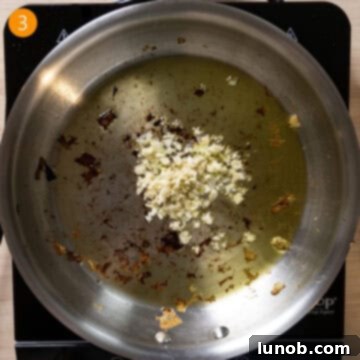 Rustic Eggplant Tomato Pasta 6 Garlic sauteing in a pan with olive oil.