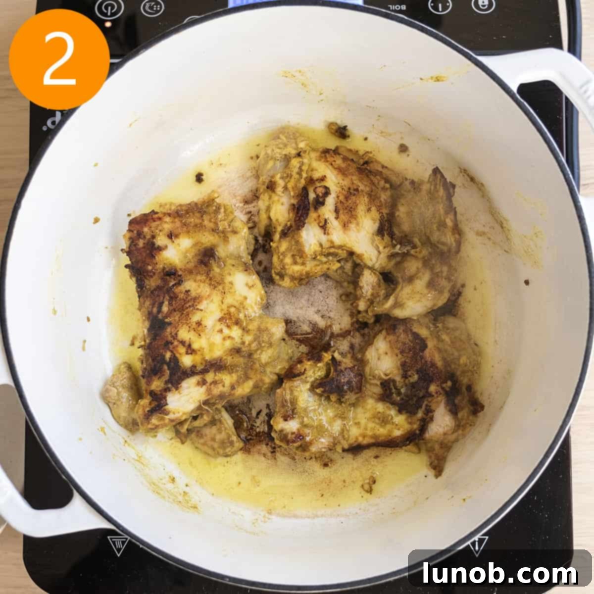 Velvet Butter Chicken Soup 6 Chicken thighs searing in a Dutch oven on the stovetop, developing a golden-brown crust.