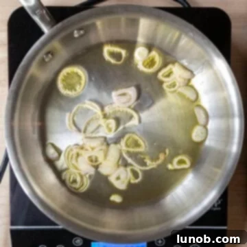 Shallots sauteing in a saucepan.