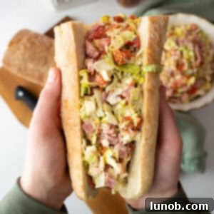 Chopped Italian Salad in an Italian sub held by two hands.