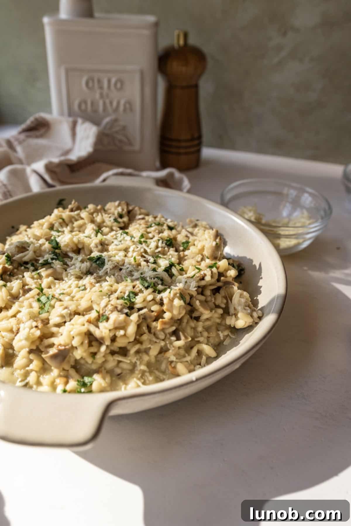A bowl of risotto with mushrooms topped with extra gorgonzola and parsley.