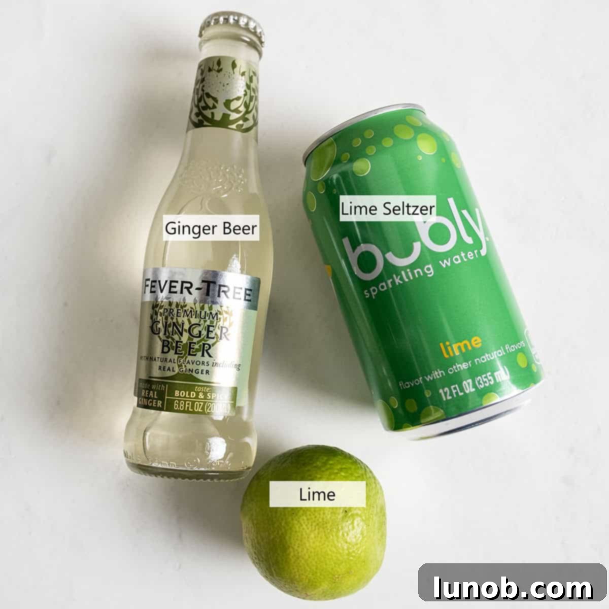 Ingredients for the non-alcoholic Moscow Mule, including ginger beer, lime seltzer, and fresh limes.